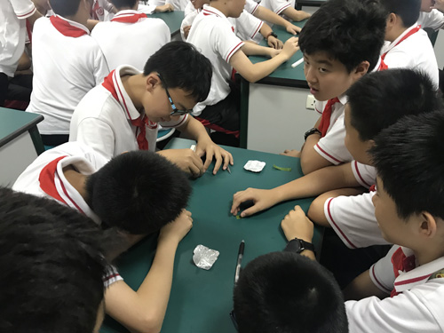 图片：学生们兴致勃勃地进行趣味实验